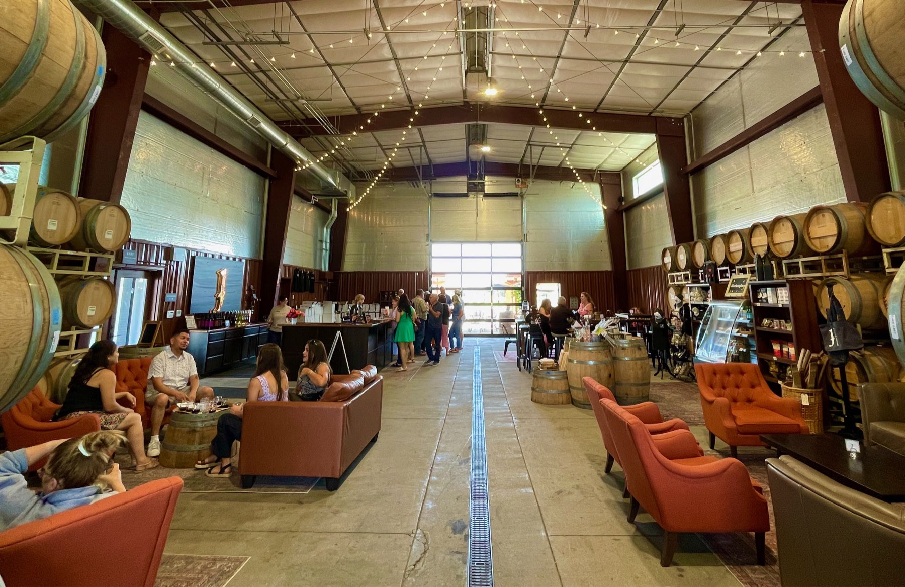Guests tasting in the Lockeford barrel room, lined with oak barrels