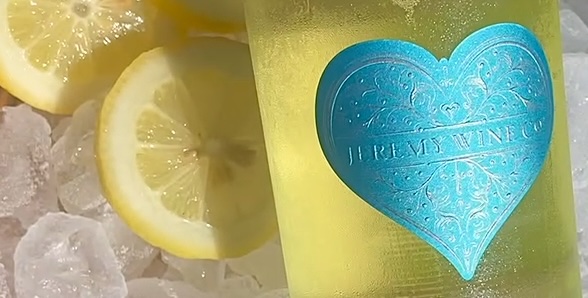 A bottle of Heart label wine chilling on ice beside lemon slices